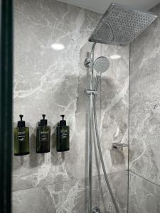 Turks and Caicos Airport Hotel في بروفيدنسياليس: دش مع زجاجتين من الصابون على الحائط