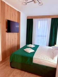 una camera con letto e TV a parete di Harmony Suite a Baia Mare
