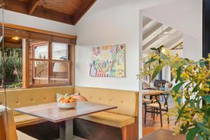 una sala da pranzo con un tavolo con una ciotola di frutta sopra di Coastal Timber Escape with Pool a Ocean Grove