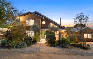 una casa in legno con un cortile di fronte di Coastal Timber Escape with Pool a Ocean Grove