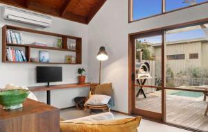 un soggiorno con porta scorrevole in vetro che conduce a un patio. di Coastal Timber Escape with Pool a Ocean Grove Altre 14 foto