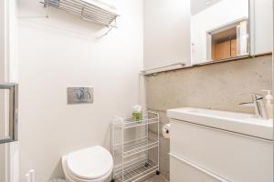 a white bathroom with a toilet and a sink at Downtown Edge-Stylish Studio Near Hospitals & Downtown-03 in Seattle +8 photos