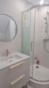 a white bathroom with a sink and a shower at apartment with large garden in Ifs
