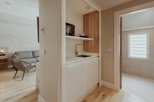a small kitchen with a sink and a living room at Hotel Reva TAHITI in Papeete