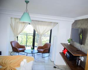 Un dormitorio con una cama y dos sillas y una mesa. en HAPPY HOME Guest house, en Gqeberha