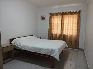 a small bedroom with a bed and a window at Spring Cottage in Walvis Bay