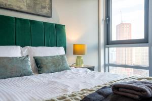 1 dormitorio con 1 cama con cabecero verde y ventana en Leeds City Views - Riverside Living - Sleeps 8 - Balcony, en Central Station