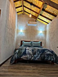 a bedroom with a bed in a room with a wooden ceiling at Chalés Recanto Vista do Valle in Monte Verde