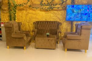 three chairs and a table in front of a wall at Tiger Complex Inn in Patong Beach