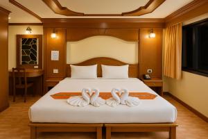 a bedroom with a bed with two swans towels at Tiger Complex Inn in Patong Beach +17 photos