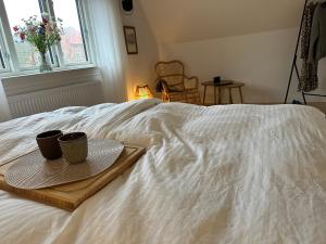 a bed with two cups and a tray on it at Modern & Unique property in Odense centrum - FREE PARKING in Odense