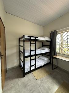 een kamer met 3 stapelbedden en een raam bij Zig Zag Hostel in Itacaré +5 foto's