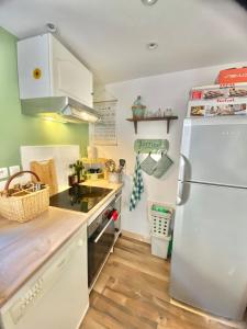 a kitchen with a white refrigerator and a sink at Agréable petite maison rustique in Saint-Geniès-de-Varensal