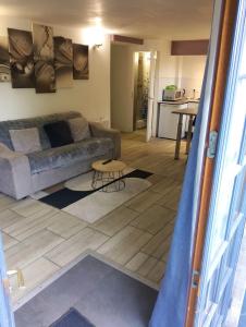 a living room with a couch and a table at Magnifique Studios proche de Paris dans le Yvelines in Ecquevilly