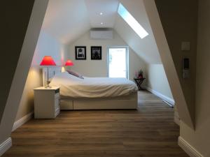 サントメールにあるMaison L'Esperance chic et calmeのベッドルーム1室(ランプ2つ、窓付)