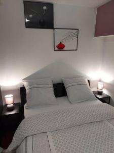 a white bedroom with a bed with two lamps at Magnifique Studios proche de Paris dans le Yvelines in Ecquevilly