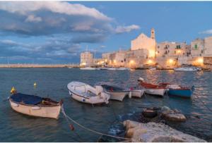a group of boats in the water near a city at Dimora Marina in Giovinazzo