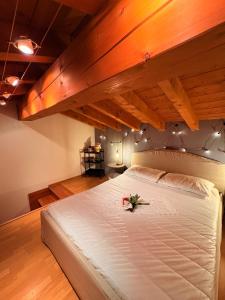 een slaapkamer met een groot wit bed met bloemen erop bij Luxury Loft -Vision Suite valle Camonica in Braone