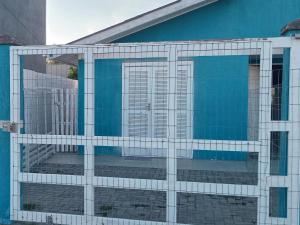 a blue building with a glass facade with a door at Aluguel casa azul in Capão da Canoa +5 photos