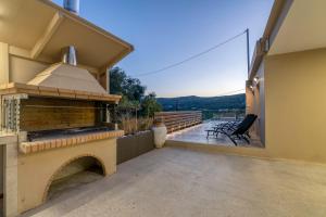 a patio with a brick fireplace on a house at Huzuri Retreat in Ayiós Nikólaos