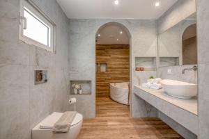 a bathroom with a toilet and a sink and a tub at Huzuri Retreat in Ayiós Nikólaos +109 photos