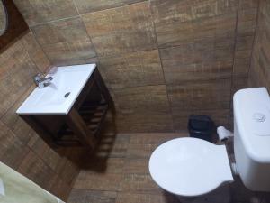 Un baño con un inodoro blanco y un lavabo. en Romu, en Villa Gesell