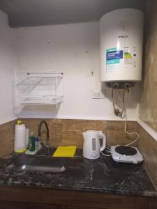 Una encimera de cocina con un fregadero y una cafetera. en Romu, en Villa Gesell