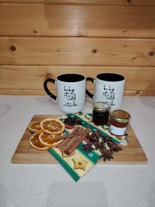 due tazze da caffè e arance su un tagliere di Nowoczesny Domek Góralski a Kielce