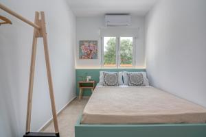 a bed in a room with a window at Huzuri Retreat in Ayiós Nikólaos