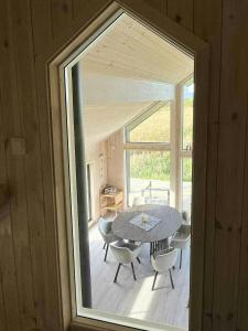 a room with a table and chairs and a window at Newly Built Cabin On Andøya With Northern Lights in Bø Andøya +13 photos
