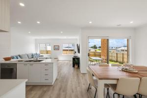 サンレモにあるBay Skies Retreatのテーブルとダイニングルームのあるキッチンとダイニングルーム