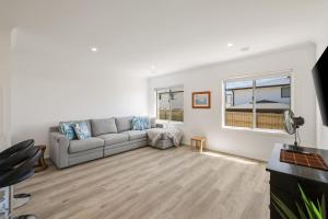 サンレモにあるBay Skies Retreatのソファと窓のあるリビングルーム