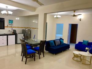 a living room with a table and a blue couch at Goa Beach Apartment in Colva