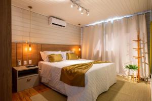 a bedroom with a large bed and a window at Condado de Urubici - Cabana in Urubici +23 photos