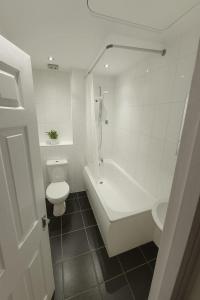 Stylish 2-Bed flat, fast Wi-Fi, Sky & free parking في Buckinghamshire: حمام مع مرحاض وحوض استحمام ومغسلة