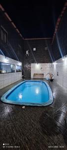 a large swimming pool in a building at night at Kitnet in Itaparica Town