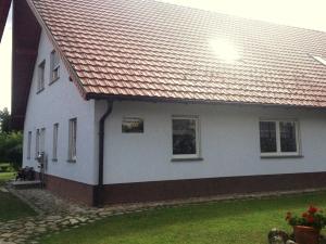 ein weißes Haus mit rotem Dach in der Unterkunft Ferienhaus Ringelwiese in Schönstedt