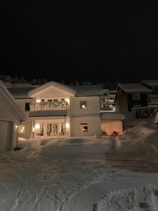 una casa bianca nella neve di notte di Klebersteinsveien 6 a Holmestrand