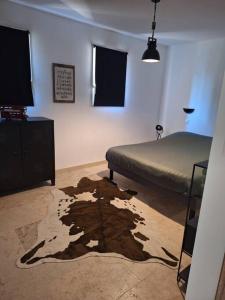 a bedroom with a bed and a rug on the floor at Maison type T3 à Ventabren in Ventabren