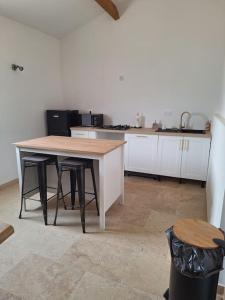 a kitchen with a wooden table and two stools at Maison type T3 à Ventabren in Ventabren