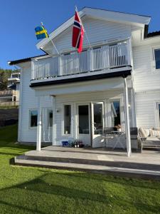 Casa bianca con balcone e bandiera di Klebersteinsveien 6 a Holmestrand