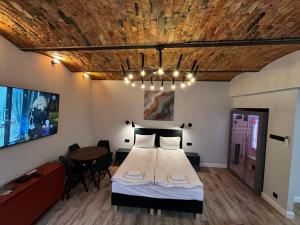 a bedroom with a bed and a table in it at Rybaki Sauna & Jacuzzi Apartment in Poznań