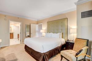 a bedroom with a large white bed and a chair at MGM Signature-15-802 1Br 2Ba F1 Pits View Balcony in Las Vegas