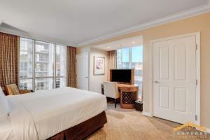 a bedroom with a bed and a desk with a television at MGM Signature-15-802 1Br 2Ba F1 Pits View Balcony in Las Vegas +65 photos