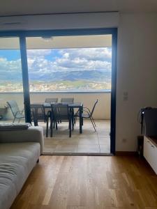 ein Raum mit Tisch und Stühlen und einem großen Fenster in der Unterkunft T2 avec vue panoramique in Ajaccio + 4 Fotos