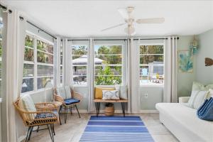 a living room with a couch and chairs and windows at Crystal Blue Haven in Crystal River