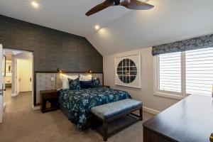 Queenstown House Lakeside في كوينزتاون: غرفة نوم بها سرير ومروحة سقف