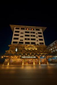 a hotel building with lights in front of it at night at Tiger Complex Inn in Patong Beach