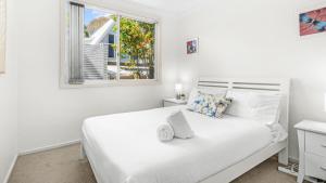 Elizabeth Beach Guest House في Elizabeth Beach: غرفة نوم بيضاء مع سرير أبيض ونافذة