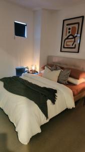Seffadom apartments Melbourne cbd في ملبورن: غرفة نوم بسرير كبير مع ملاءات ووسائد بيضاء +11 صورة